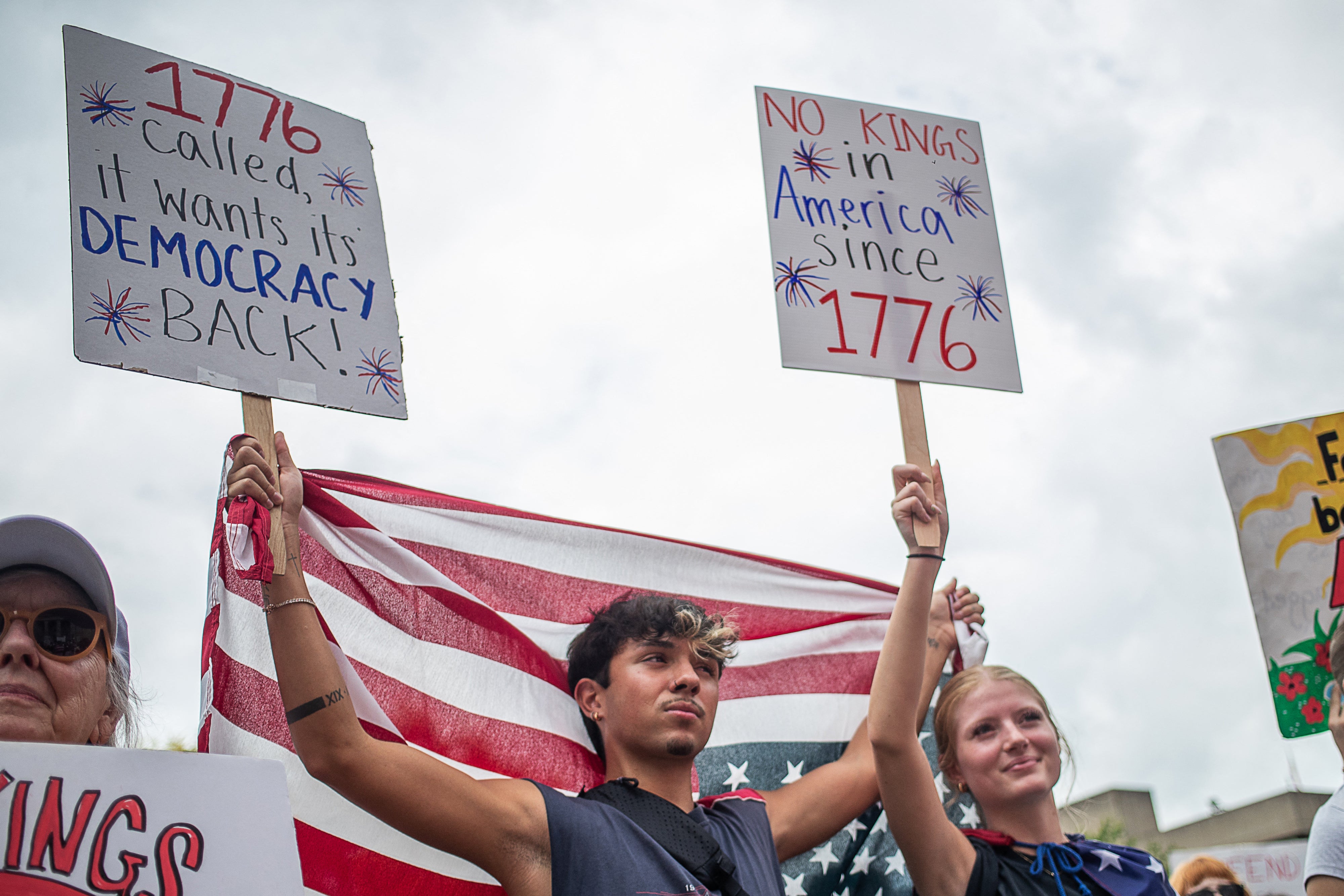 Des manifestants brandissaient des drapeaux américains et des pancartes pro-démocratie lors d’un rassemblement « No Kings » (« Pas de rois ») tenu à Louisville, dans le Kentucky, le 14 juin 2025. 