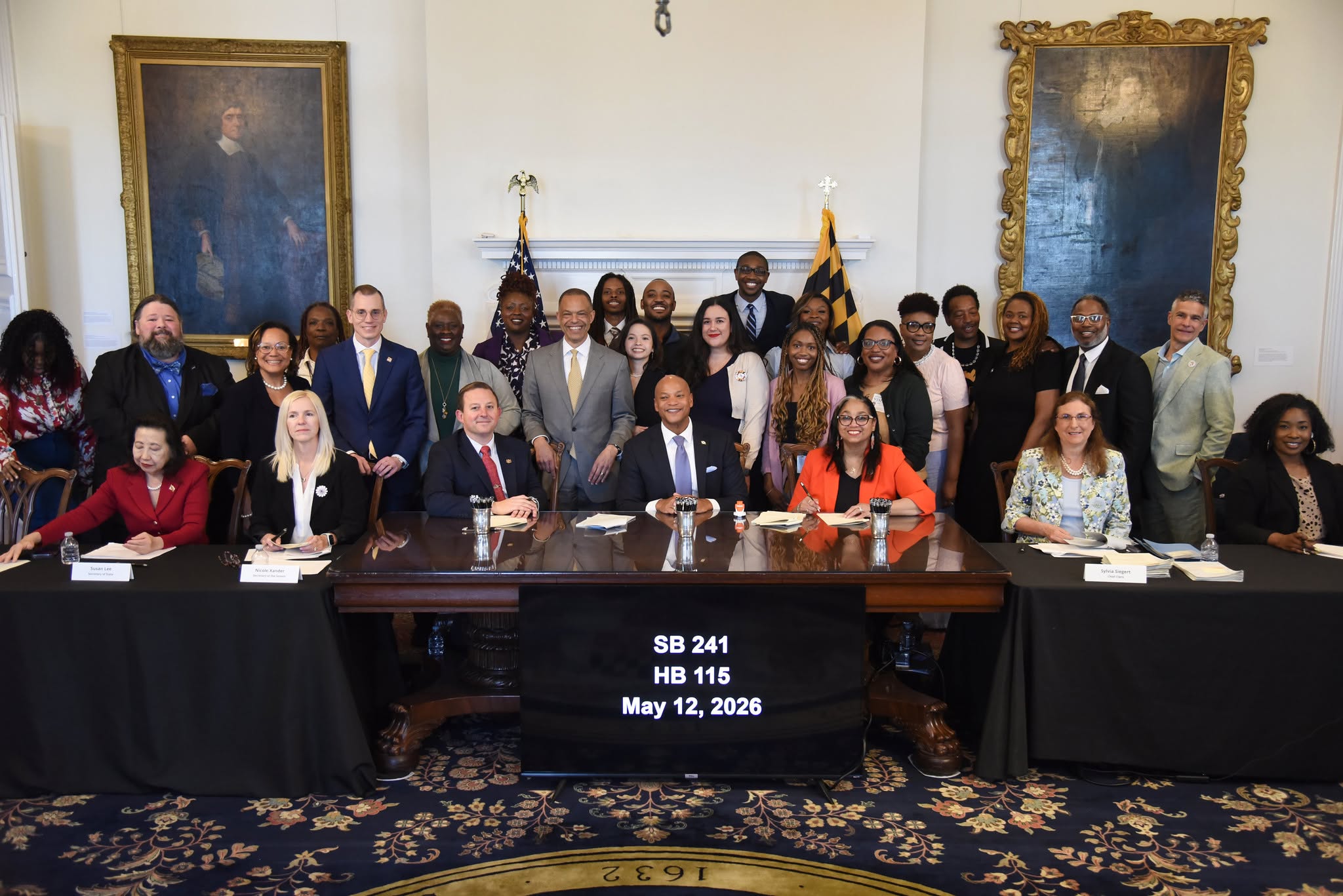Maryland Governor Wes Moore (center) along with advocates, organizers, and legislators after signing HB 115 and SB 241 at the Maryland State House in Annapolis, May 12, 2026. 