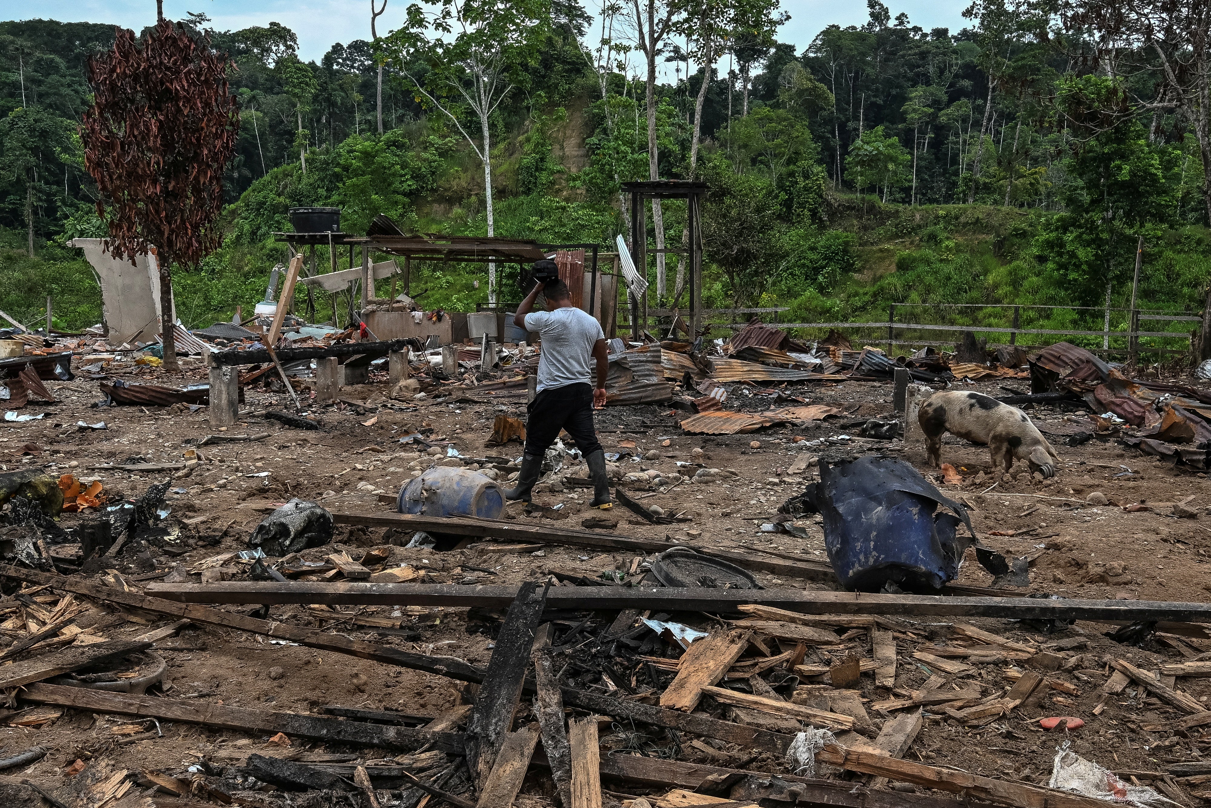 A farmer walks amidst rubble