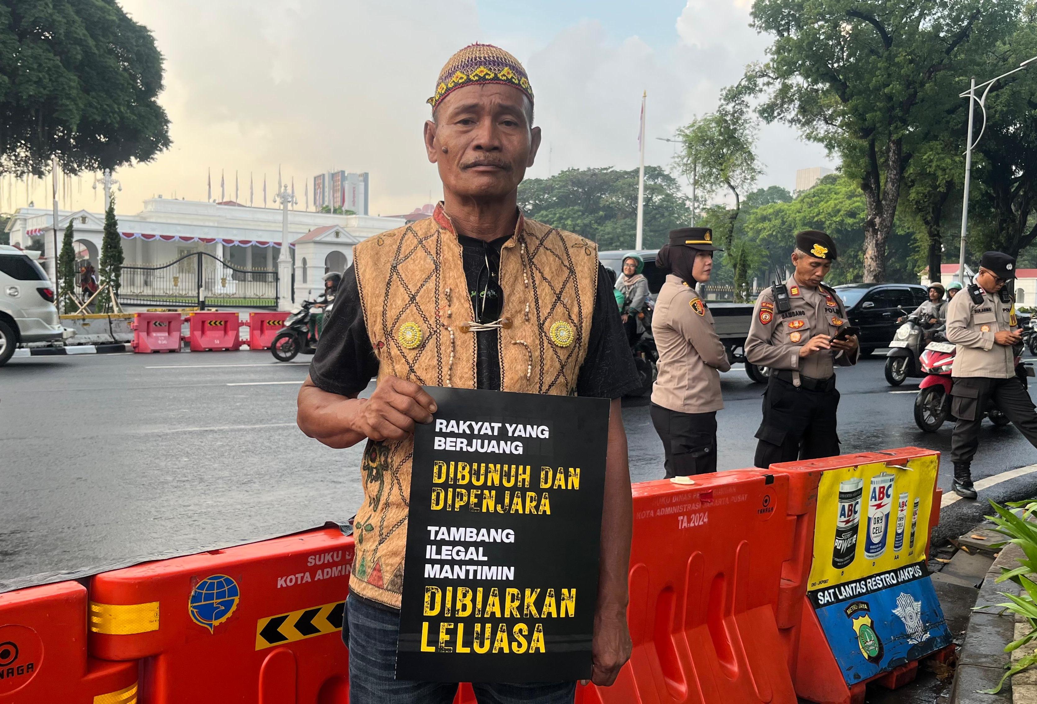 A man holds a placard at a demonstration