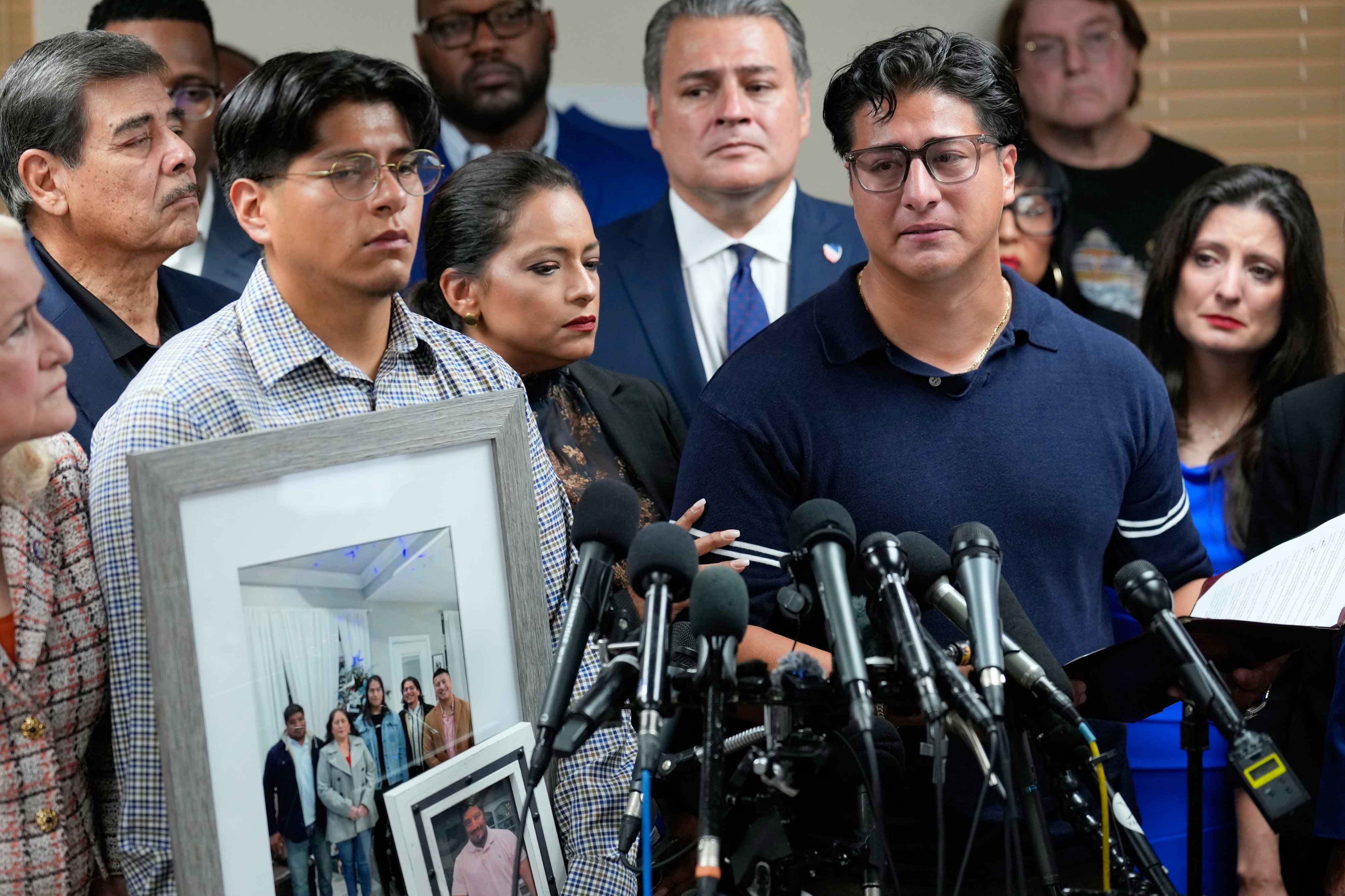 Ronaldo Salgado (right), son of Lorenzo Salgado Araujo, speaks as his brother, Lorenzo Jr. holds family photographs during a news conference in Houston, Texas, July 8, 2026.