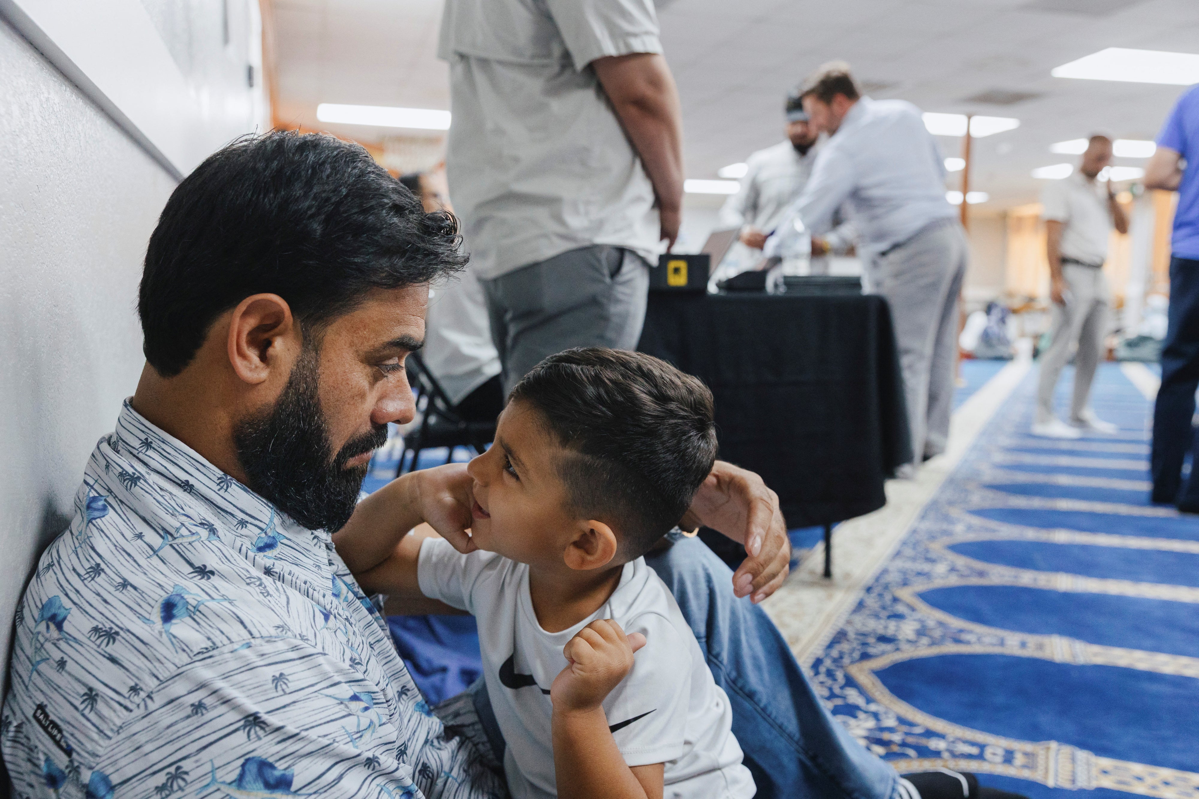 Naseer Ahmad Paktiawal holds Abubakar Paktiawal, son of his brother Mohammad Nazeer Paktiawal, who died in ICE custody, at the Abu Hanifa Mosque in Richardson, Texas, U.S. June 4, 2026.