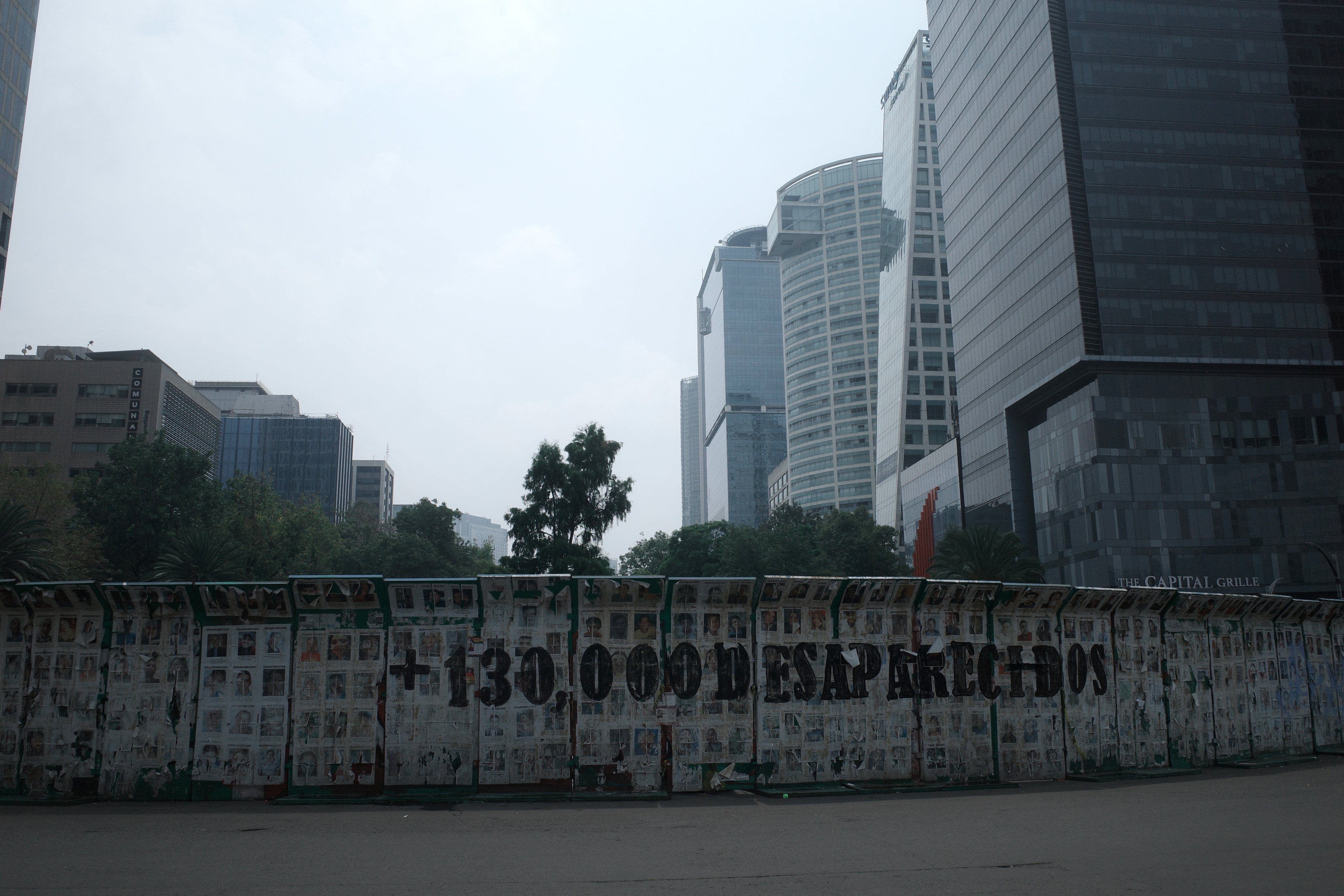 One of the government barriers surrounding the Glorieta de los Desaparecidos roundabout bears the message: "130,000 disappeared."