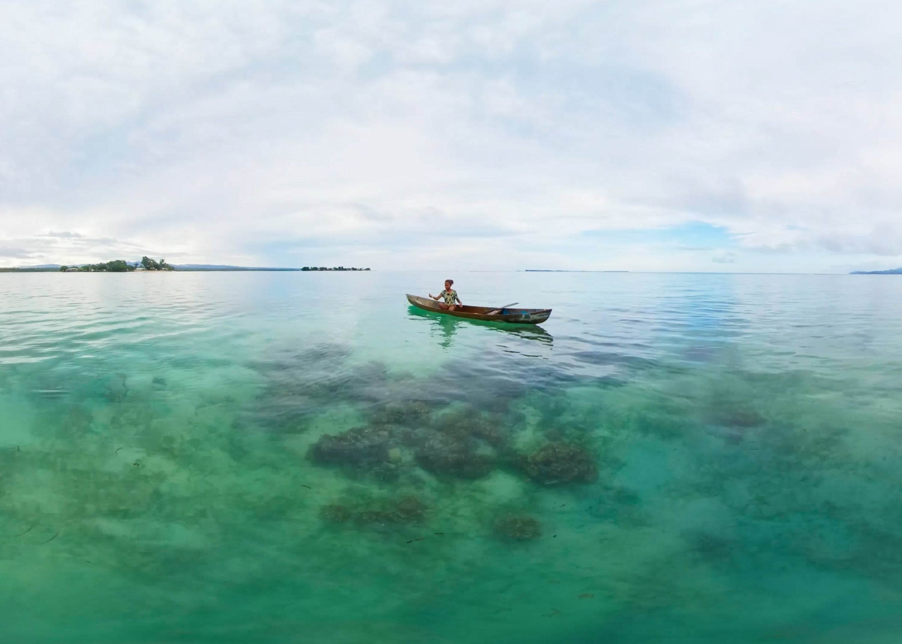 A girl in her fishing boat off the coast of Malaita Province, Solomon Islands. 