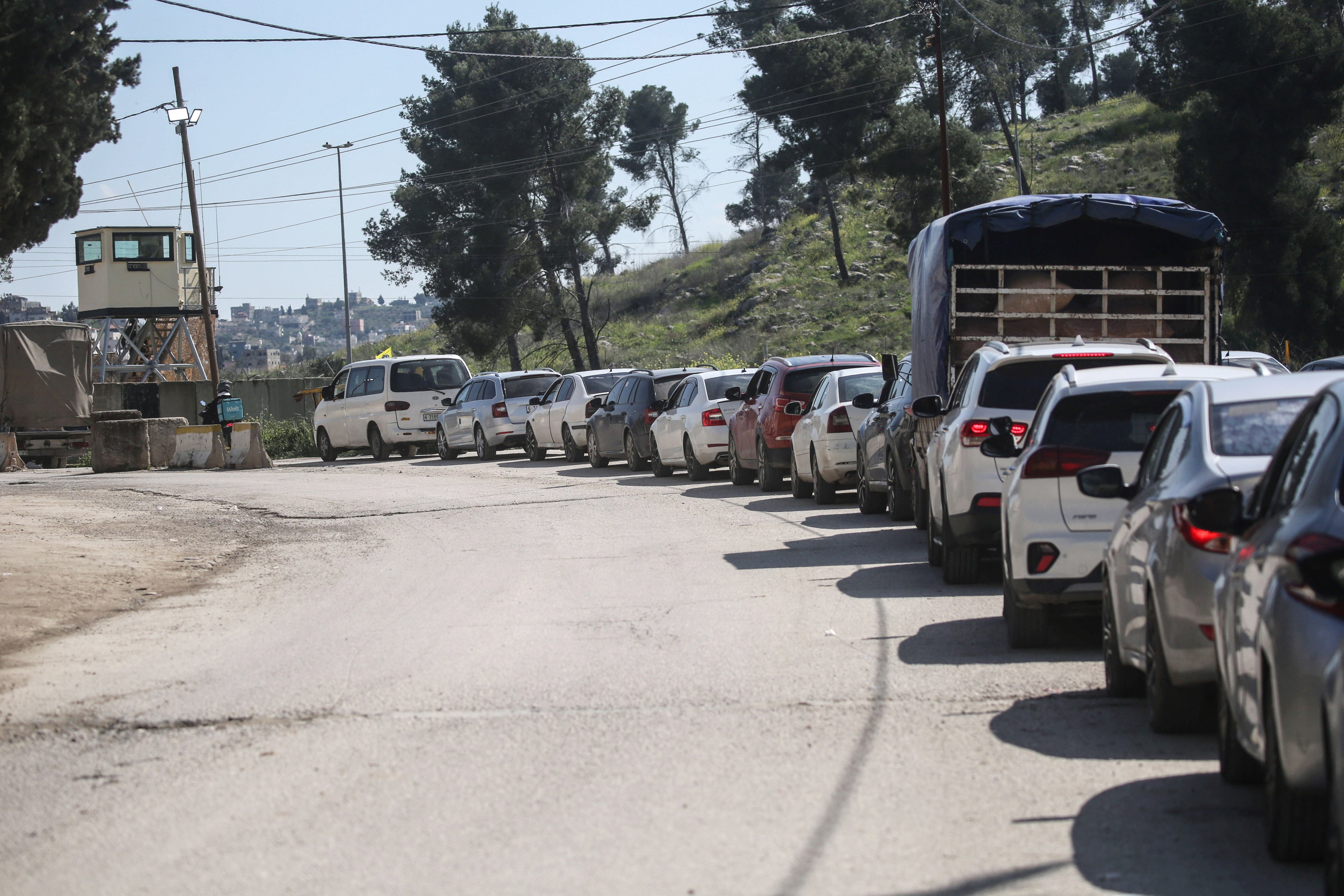 פלסטינים ממתינים במחסום שהציב הצבא הישראלי בעוורתא, מדרום לשכם שבגדה המערבית, ב-23 במרץ 2025.