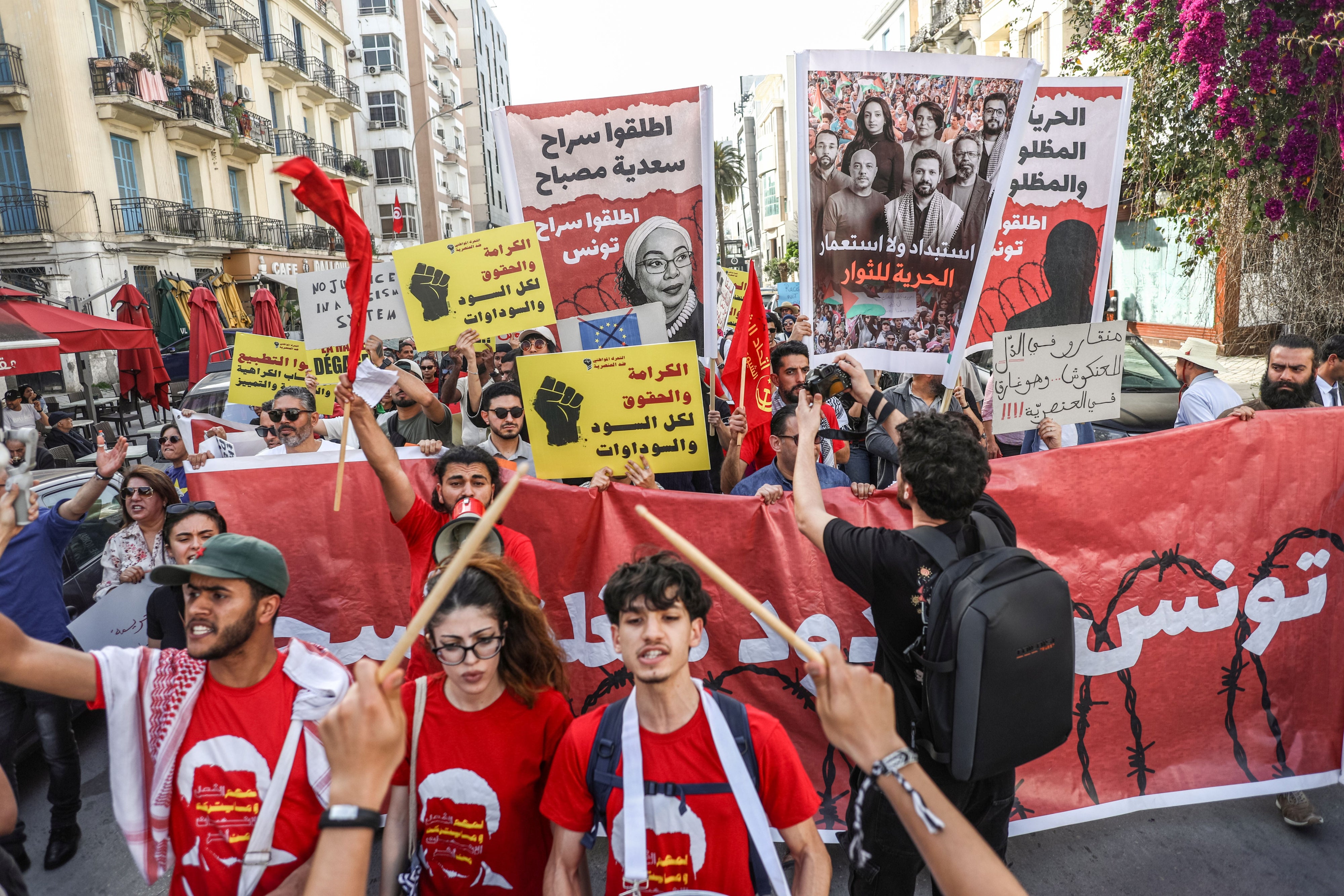Des Tunisiennes et Tunisiens brandissaient des pancartes lors d'une marche contre le racisme organisée par la Campagne contre la criminalisation de l'action civile à Tunis, le 11 avril 2026. 