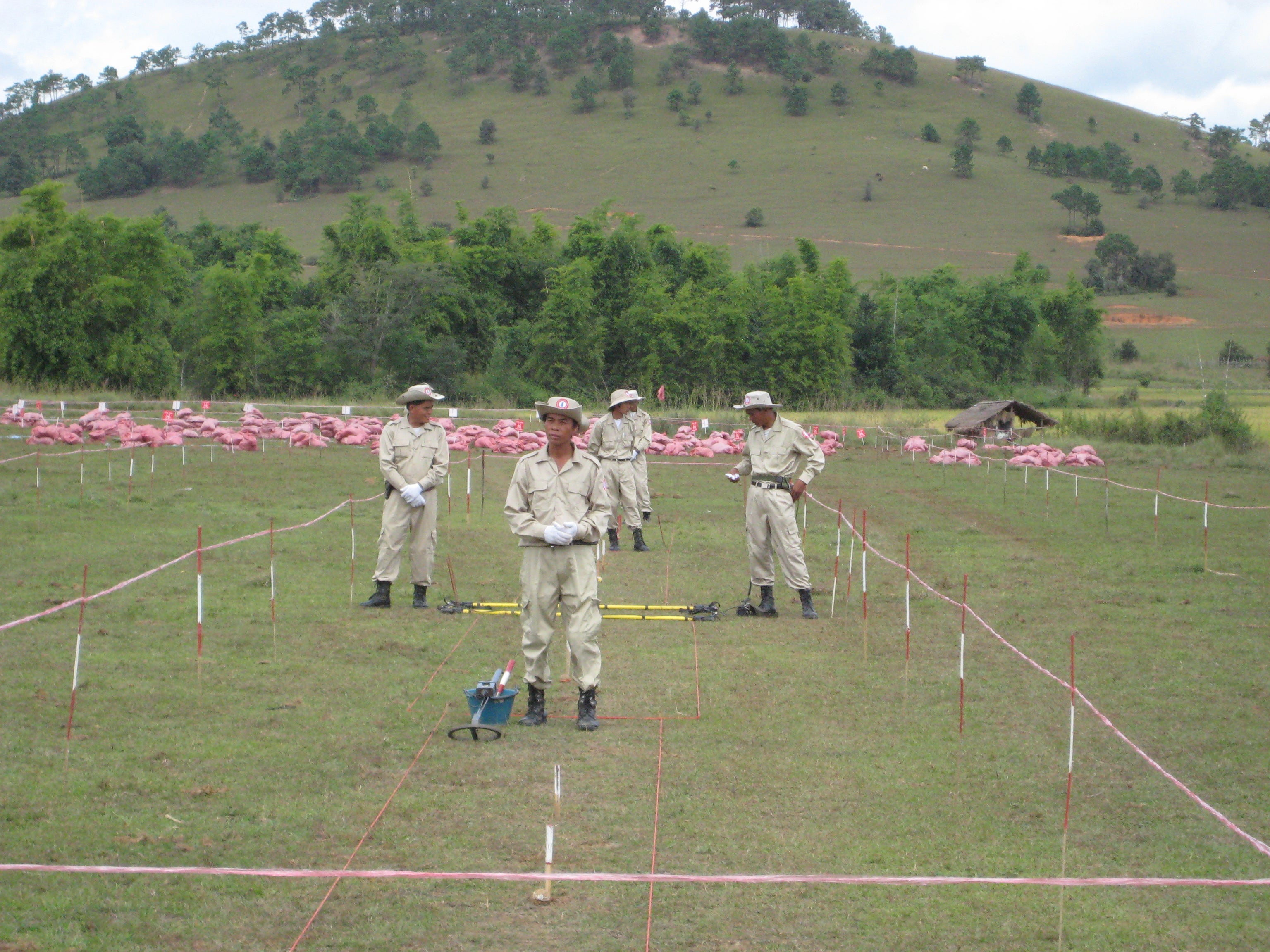 Red sandbags cover unexploded submunitions awaiting destruction near a school in Xiang Khouang Province, Laos