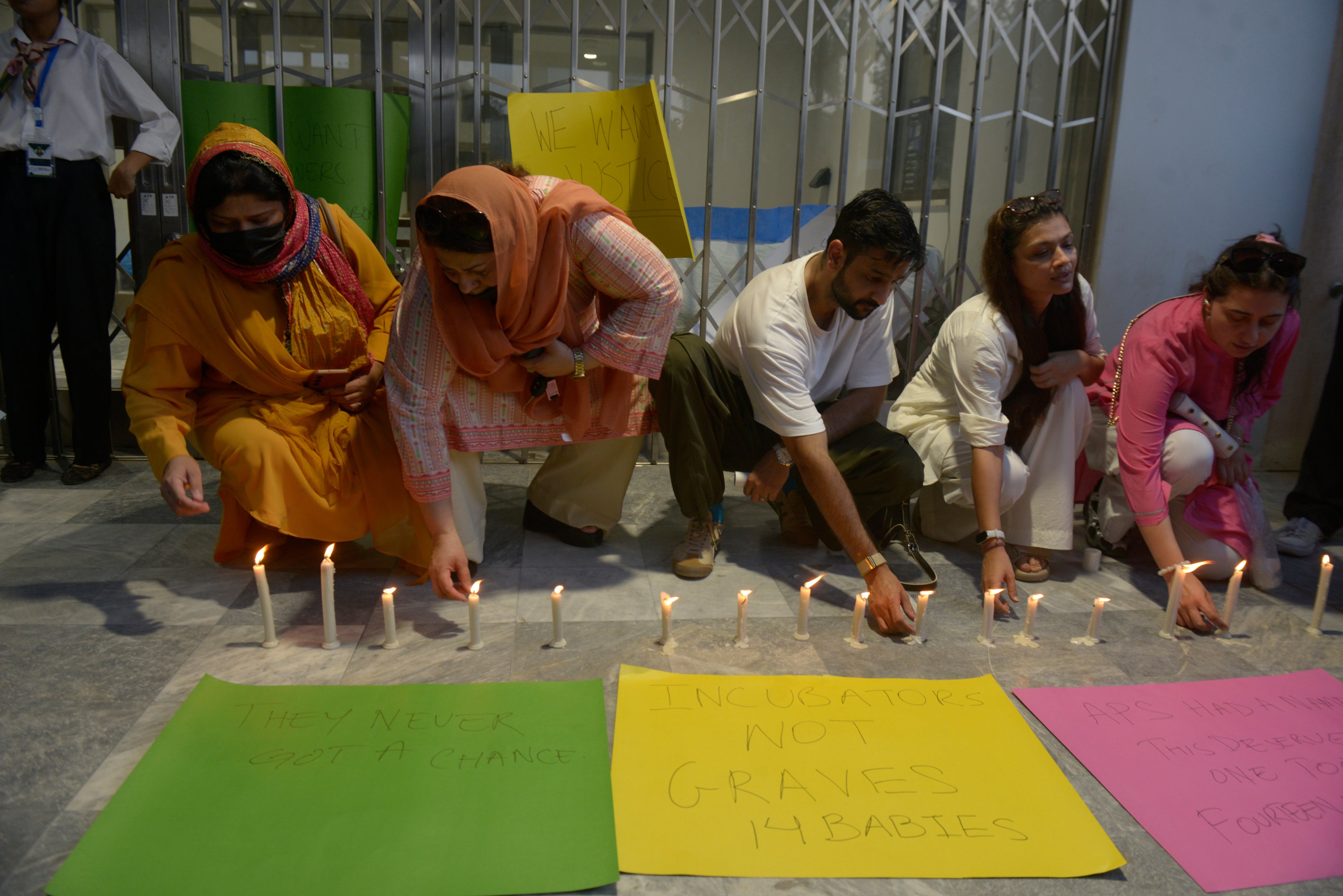 People light candles in memory of the newborn victims outside the Pakistan Institute of Medical Sciences, in Islamabad, Pakistan, August 27, 2026. 
