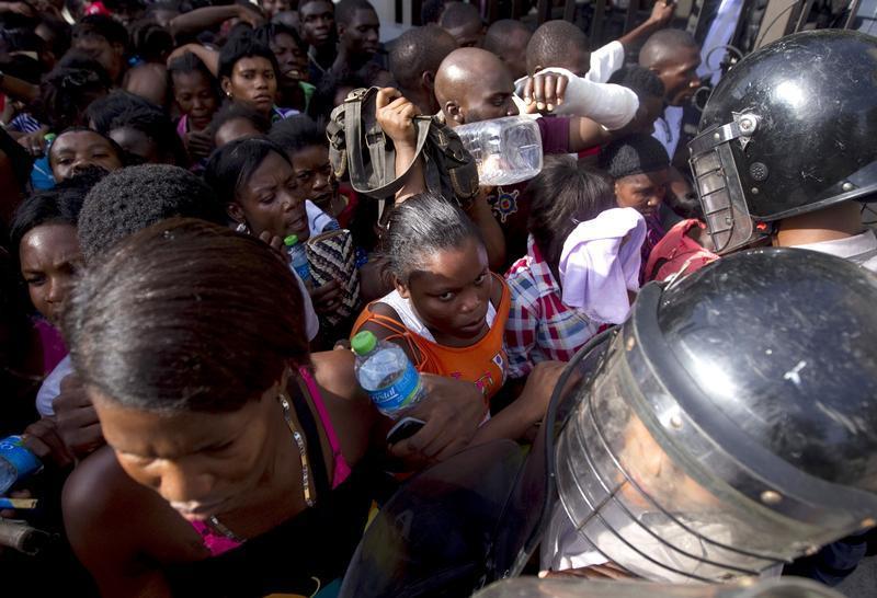 Haitianos se enfrentan a la policía mientras hacian fila frente al Ministerio del Interior con el propósito de registrarse