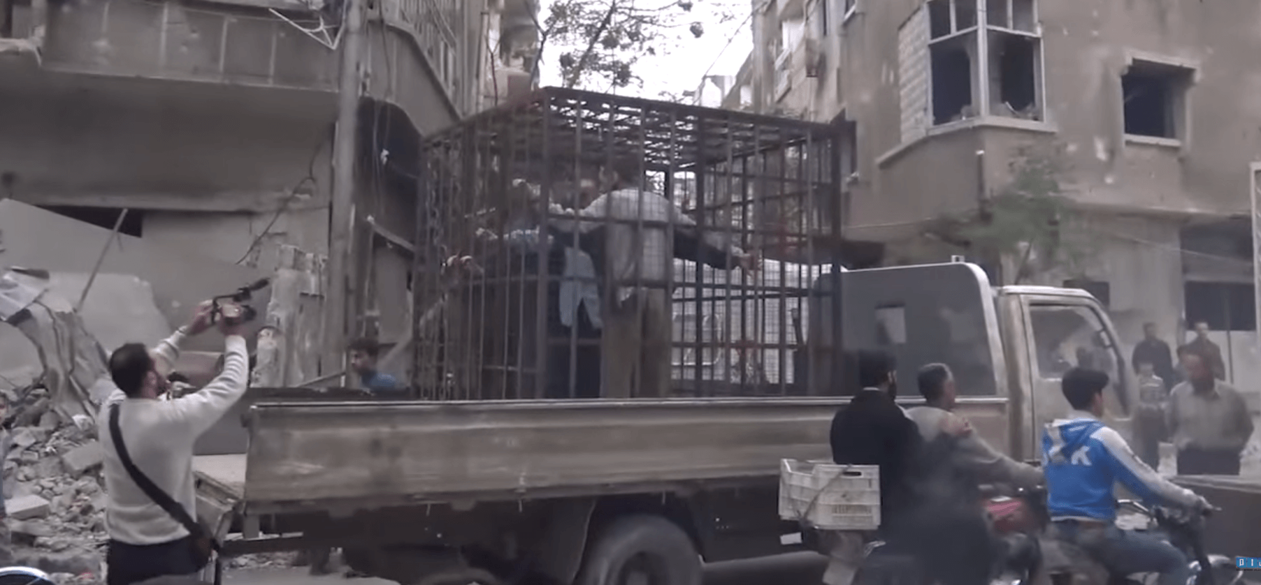 صورة من مقطع فيديو يُظهر مدنيين محتجزين في قفص في الغوطة الشرقية، سوريا. من موقع شبكة شام الإخبارية على يوتيوب. 