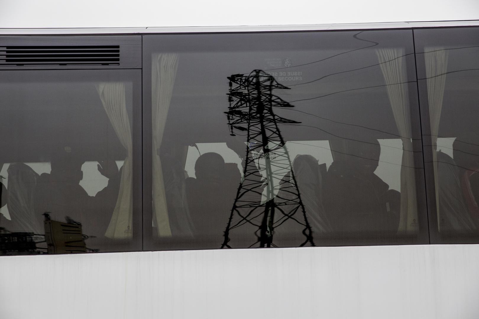Former camp residents wave as they depart in buses for migrant centers elsewhere in France. 24 October 2016.
