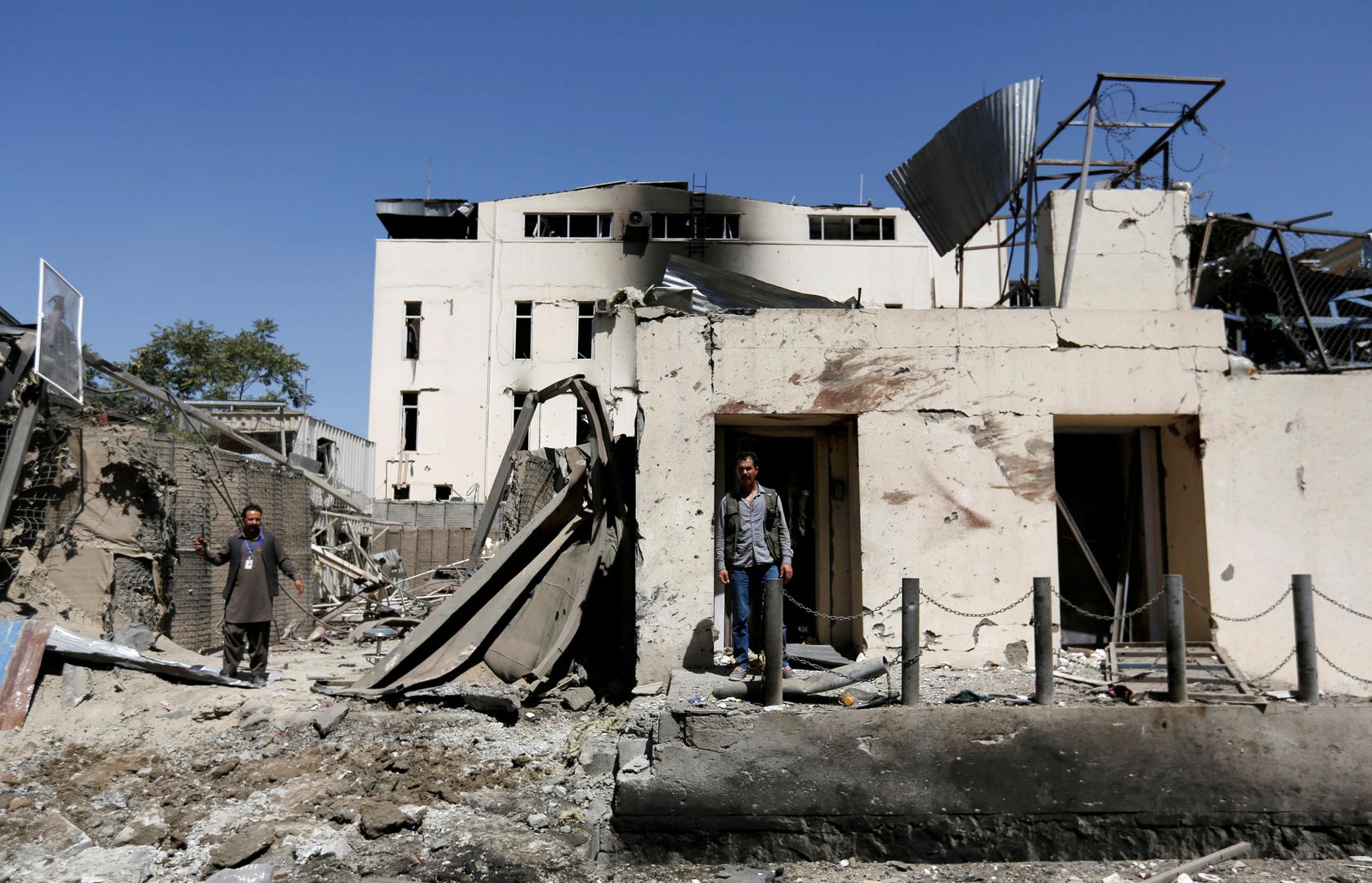 Afghan men stand at the site of a car bomb attack in Kabul, Afghanistan, September 6, 2016. 