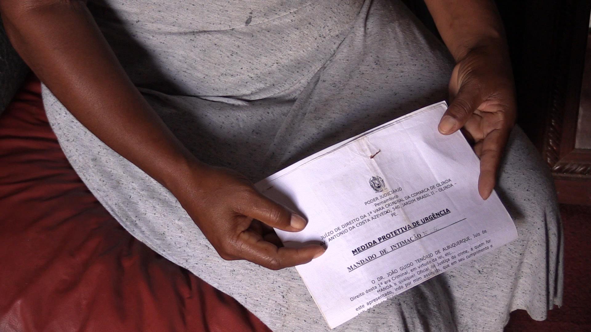 "Rita", vítima de violência doméstica, segura uma medida protetiva emitida por um juiz em Pernambuco. Outubro de 2016.