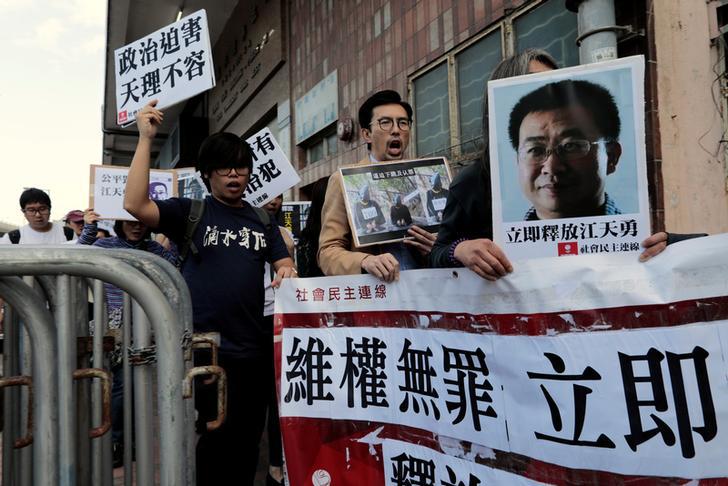 民主派示威人士在中联办门外举起被吊照律师江天勇的照片，要求将他释放，中国香港，2016年12月23日。