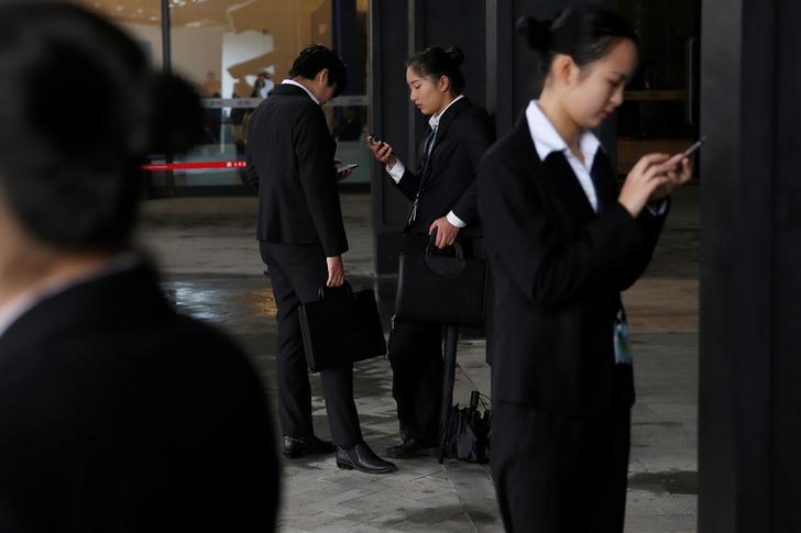 世界互联网大会工作人员在会场外滑手机，中国乌镇，2016年11月17日。