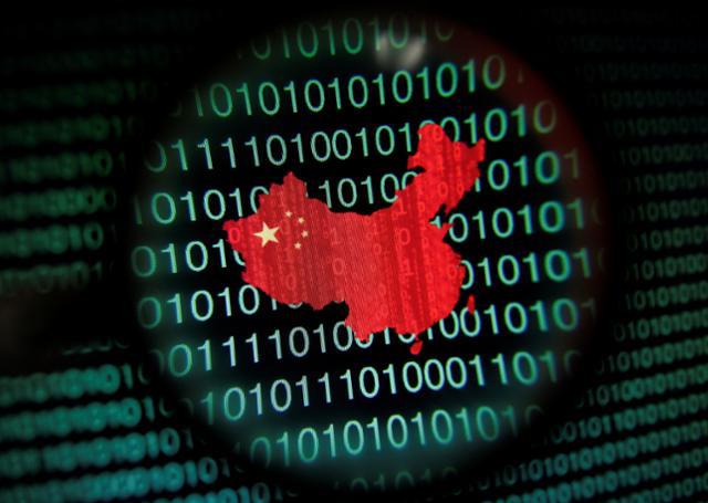 透过放大镜看电脑屏幕上以二进位数列为背景的中国地图，新加坡，2014年1月2日。