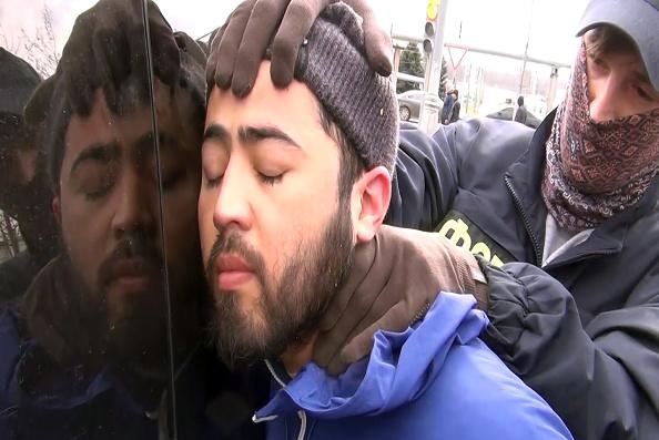 Russian Federal Security Service officers hold Akram Azimov, one of two brothers accused in connection with the April 3, 2017 suicide bombing on a subway train in St. Petersburg.