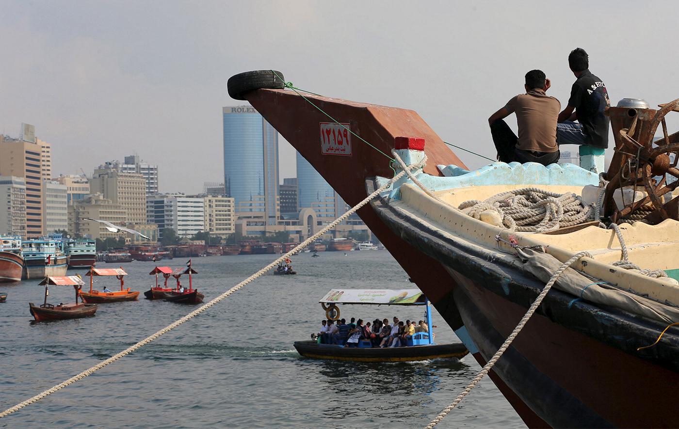 Deux travailleurs iraniens assis près de la proue d’un vaisseau de commerce arrimé dans la Crique de Dubai (Dubai Creek), aux Émirats arabes unis, le 17 janvier 2016.