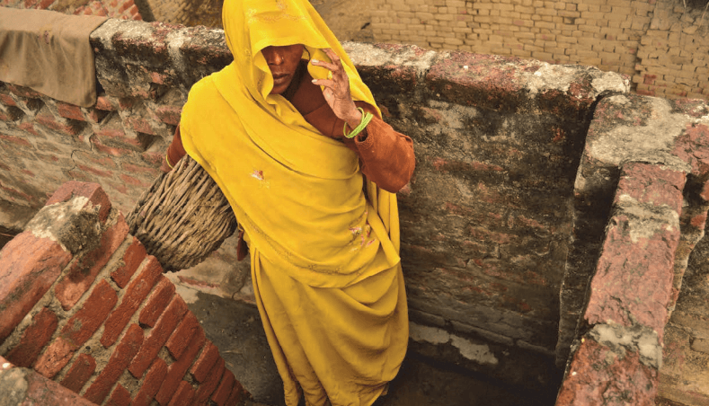A Dalit woman removes excrement from dry toilets in Kasela village in Uttar Pradesh, India, where the state has failed to enforce laws prohibiting the practice of “manual scavenging.” 