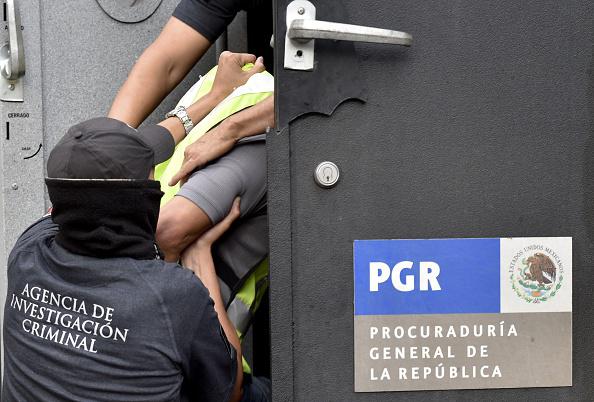 Attorney's General office's special agents embark into an armoured car some of the 27 municipal policemen involved in an attack against students in Iguala last month and now presented to the press in Mexico City on October 17, 2014. 