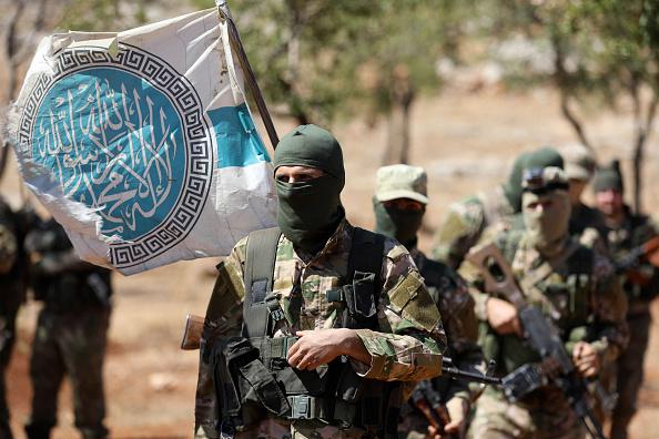Des combattants du groupe armé Hayat Tahrir al-Cham, lié à Al-Qaïda, participent à des exercices militaires dans la région d’Idlib, dans le nord de la Syrie, le 14 août 2018.