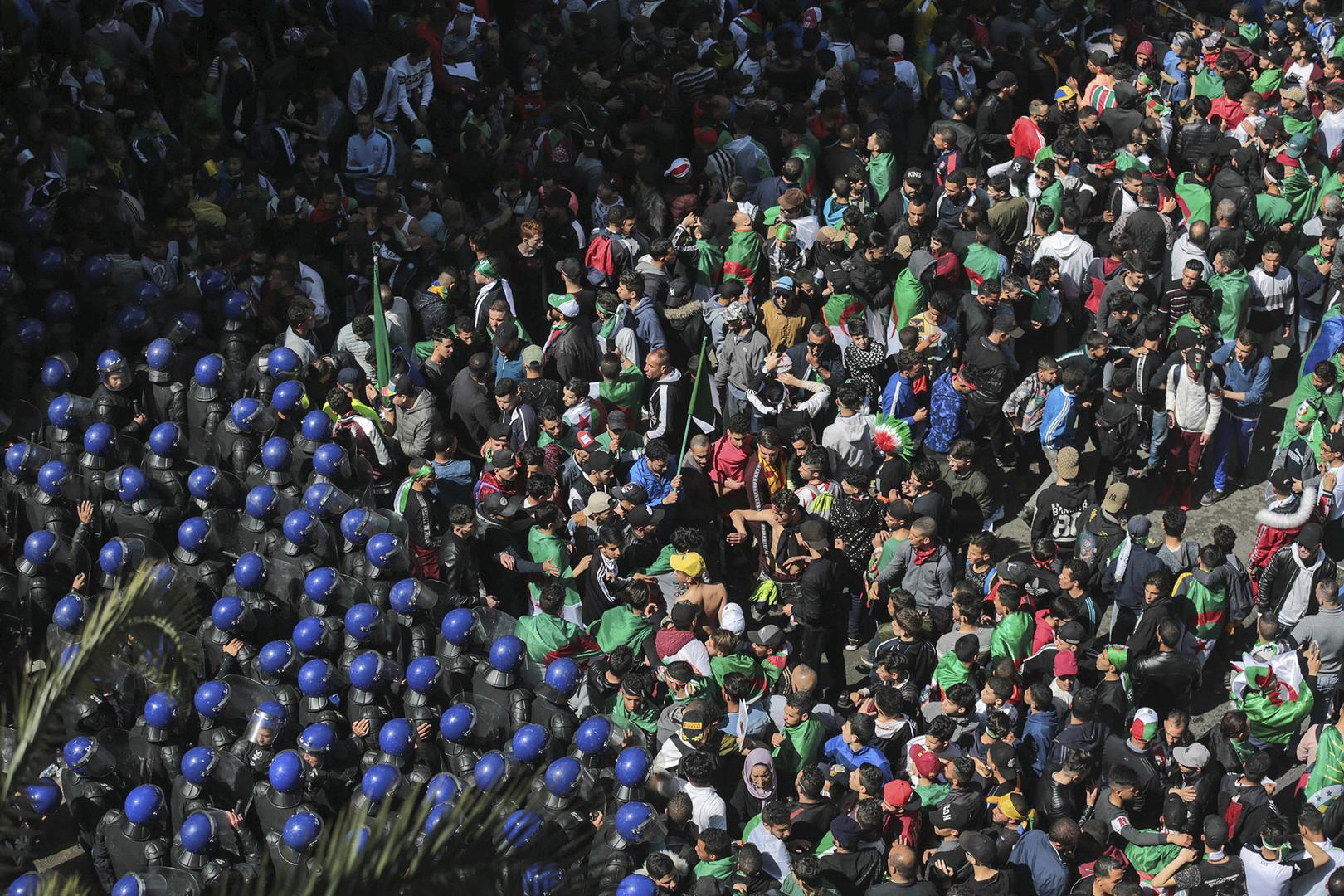 Des policiers algériens face à des manifestants lors d'un rassemblement massif contre le gouvernement à Alger, le 12 avril 2019.