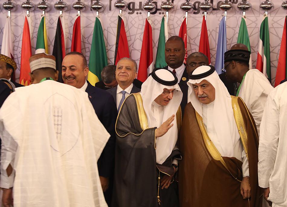 أمين عام منظمة التعاون الإسلامي يوسف بن أحمد العثيمين (وسط) ووزير الخارجية السعودي إبراهيم العساف (يمين) يتحدثان قبل التقاط صورة خلال اجتماع لوزراء خارجية دول عربية وإسلامية في جدة، 30 مايو/أيار 2019