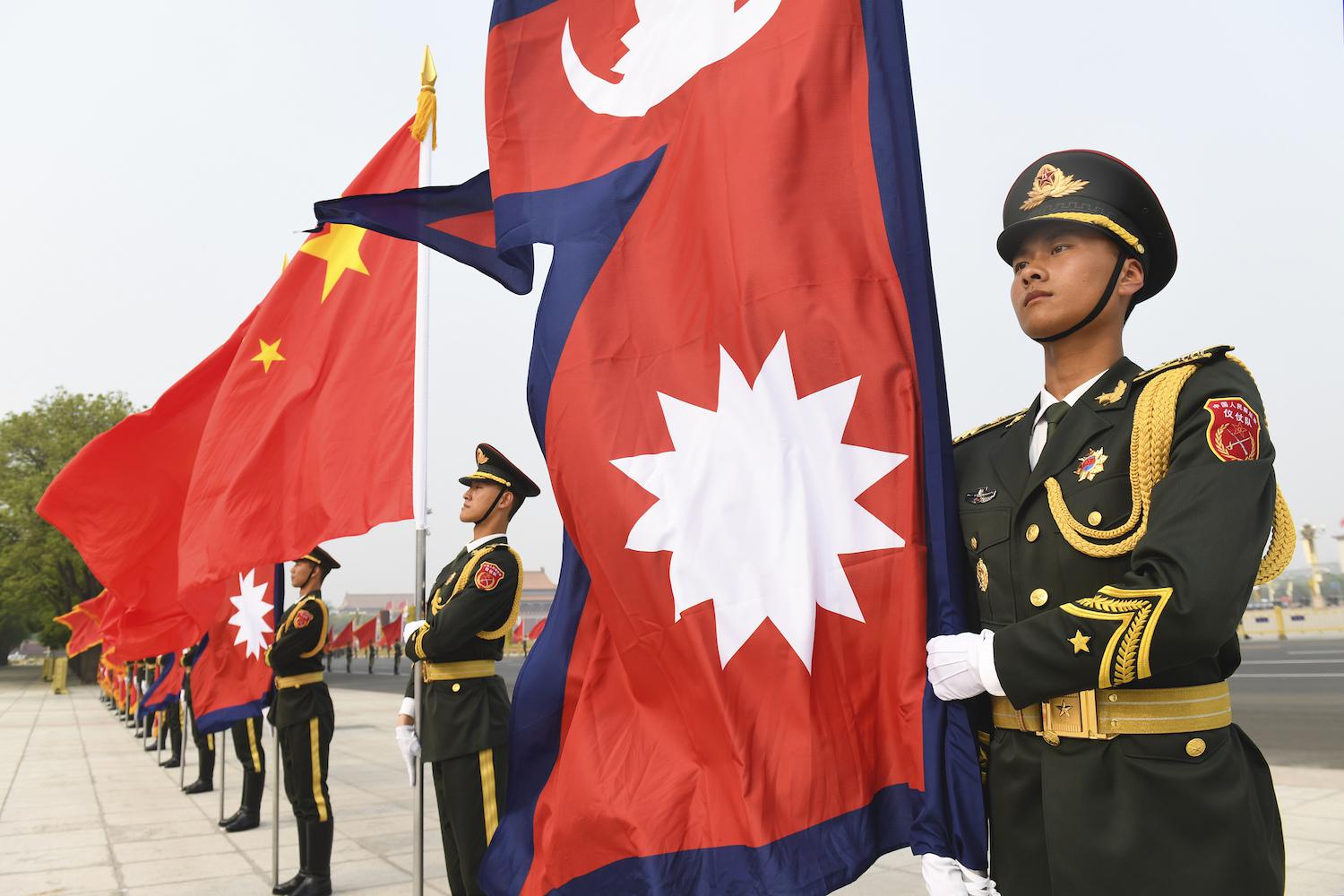 Chinese Honour Guard stand with Nepalese and Chinese flags ahead of a welcoming ceremony for the Nepalese President Bidhya Devi Bhandari