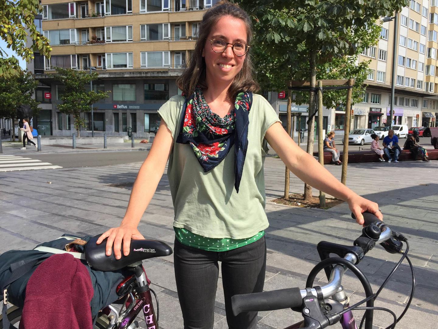 A young woman standing next to her bike