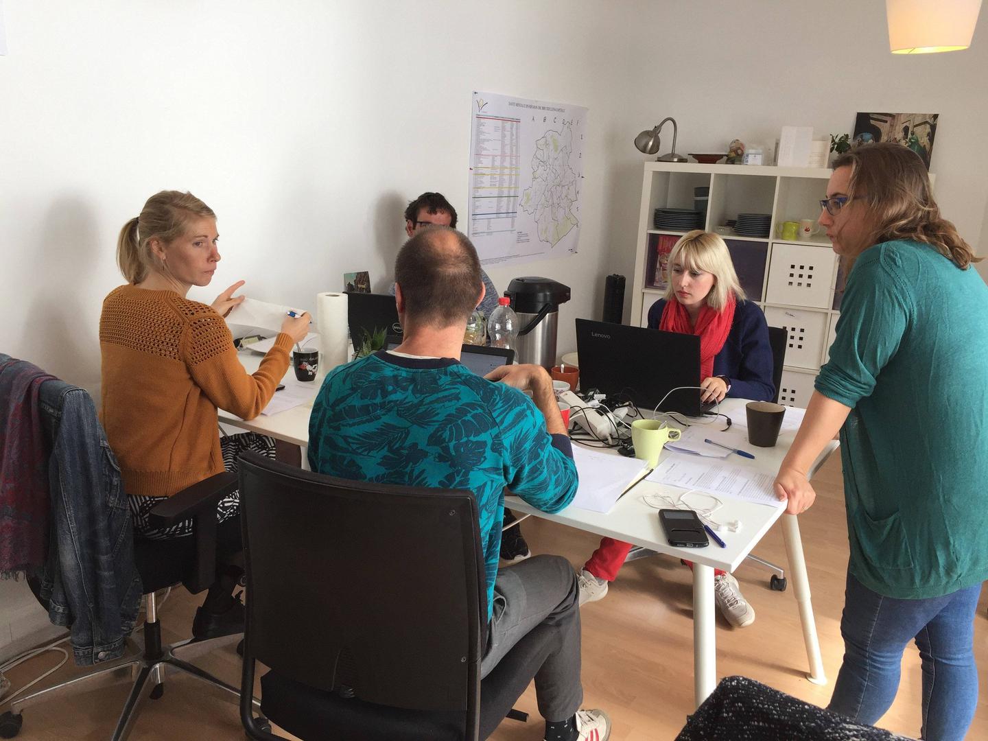 A group of people sitting around a table in an office