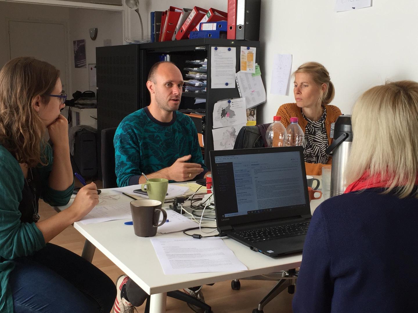 A group of people sitting around a table in an office