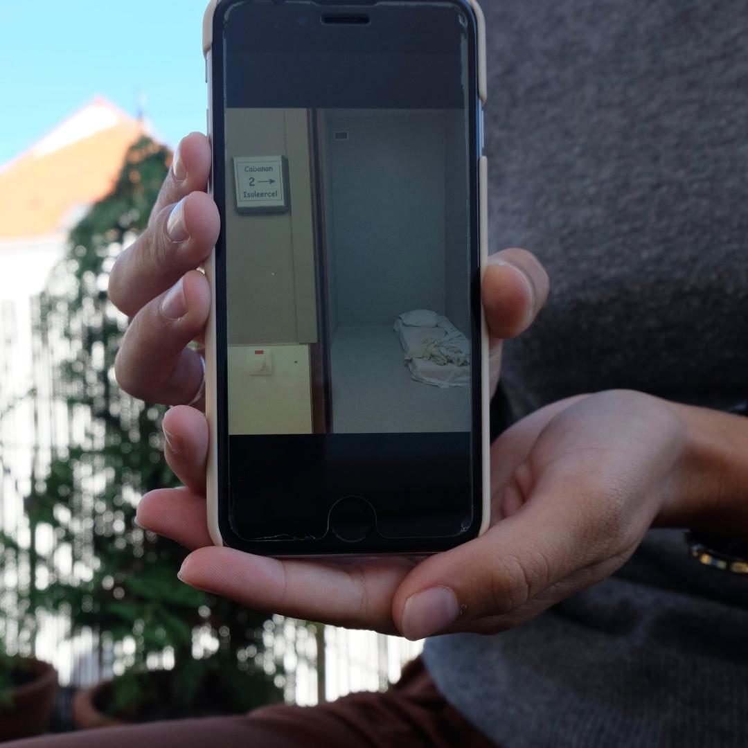 A phone displaying a photo of an isolation room