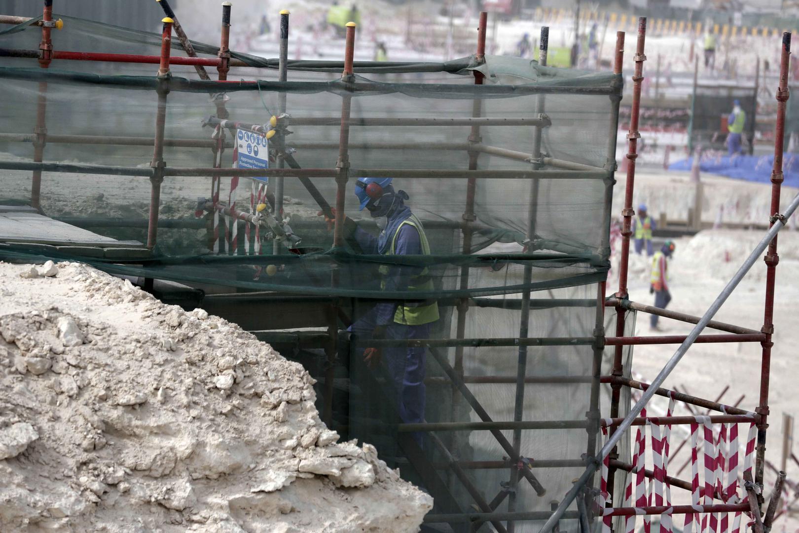 A foreign worker climbs scaffolding at the Al-Wakra Stadium that is under construction for the 2022 World Cup, in Doha, Qatar. 