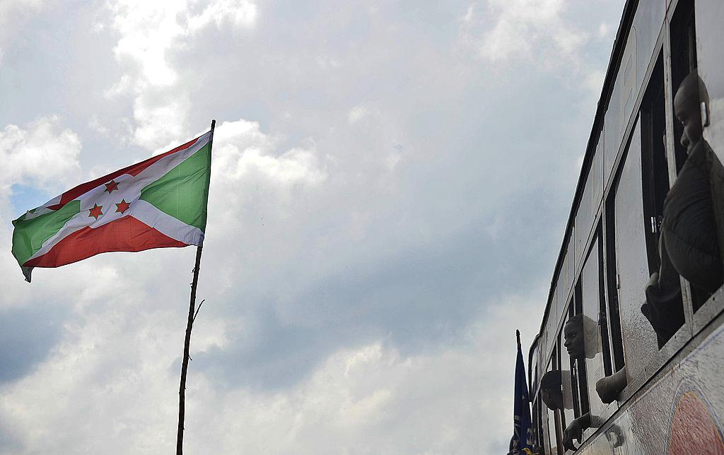 Des réfugiés burundais rentrés d’un camp en Tanzanie regardent le drapeau du Burundi après leur arrivée en bus dans un camp de transit à Musenyi, dans le sud du Burundi, le 14 novembre 2012.