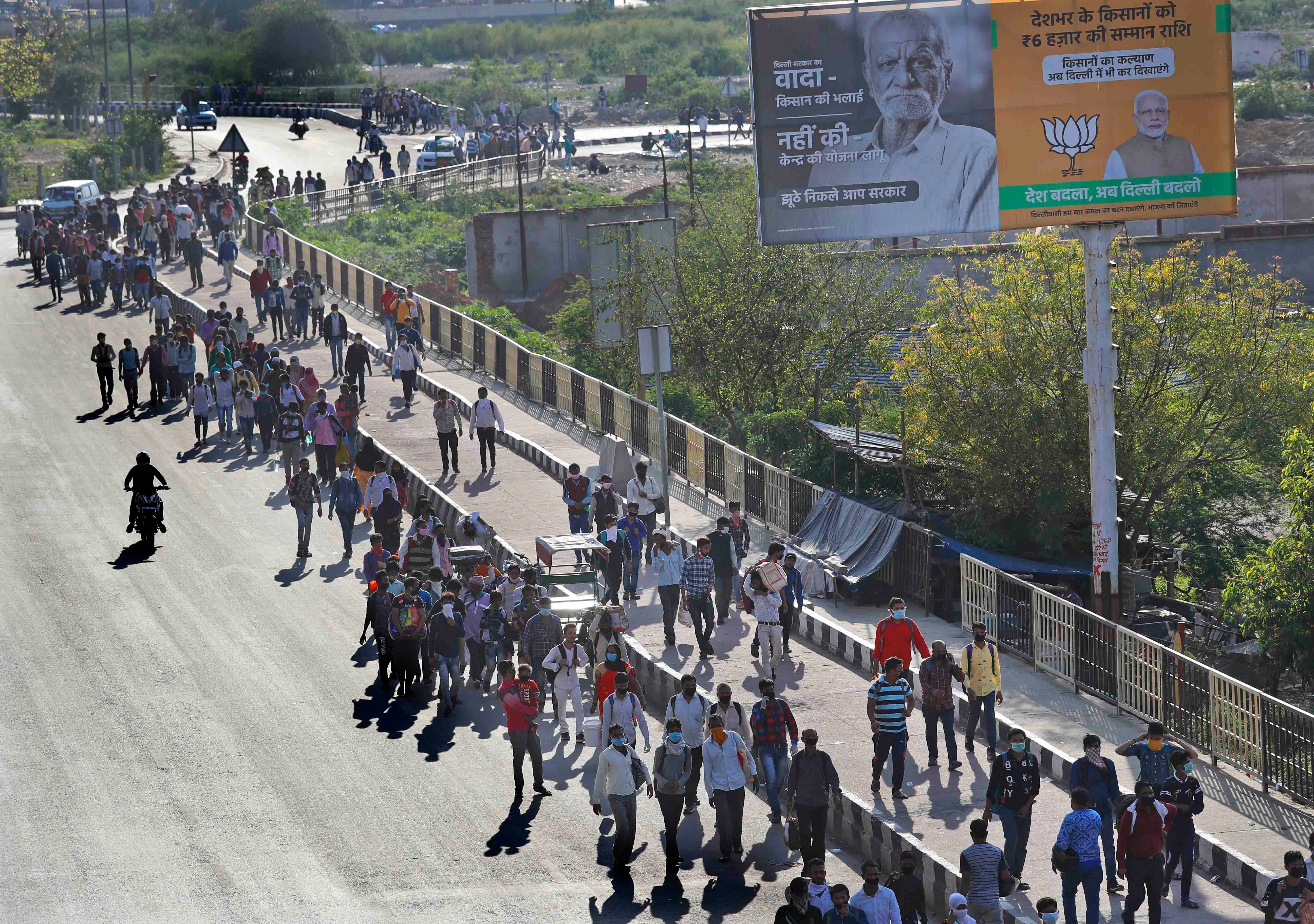 Des travailleurs migrants qui se trouvaient à New Delhi entament une longue marche pour retourner dans leurs villages le 27 mars 2020, suite à l’annonce du décret de confinement général en Inde, et à la forte réduction des services de transport public. 