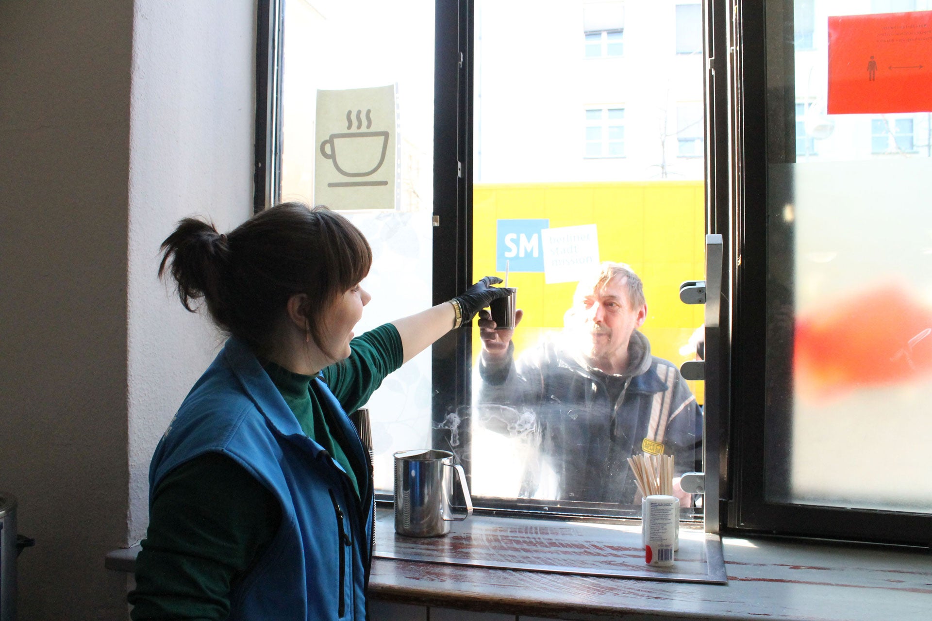 Hot drinks for homeless people: A Bahnhofsmission team member passes out hot drinks, Berlin, Germany.