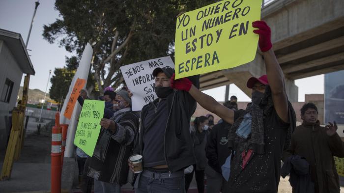 Migrants demonstrate at the border between Tijuana and San Diego calling on US authorities to open the border and restart the process of accepting asylum applications, February 18, 2021.
