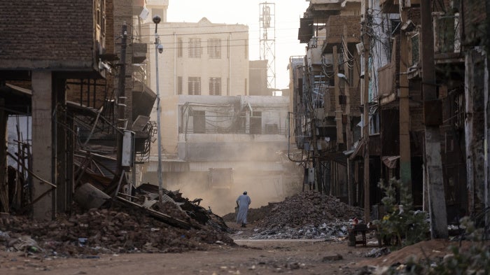 People pass through a destroyed section of Omdurman, Sudan on May 25, 2025. 