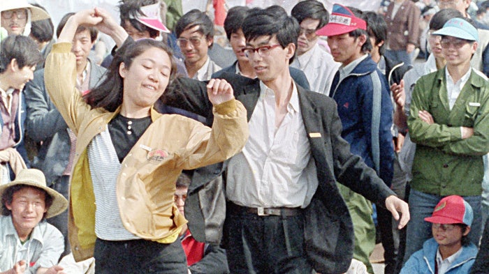 University students dance during the pro-democracy demonstration in Tiananmen Square on May 22, 1989, in Beijing, China. 