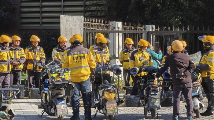 Food delivery workers are lining up to collect orders in Shanghai, China, January 14, 2024. 