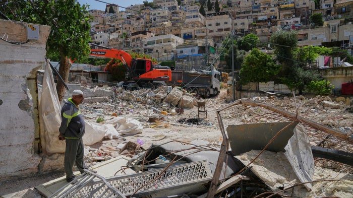 A Palestinian man looks on as an excavator clears the rubble of homes demolished by Israeli authorities in the Silwan neighborhood of east Jerusalem, May 19, 2026.