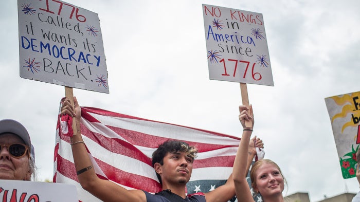 Protesters hold US flags and placards during a nationwide "No Kings" rally