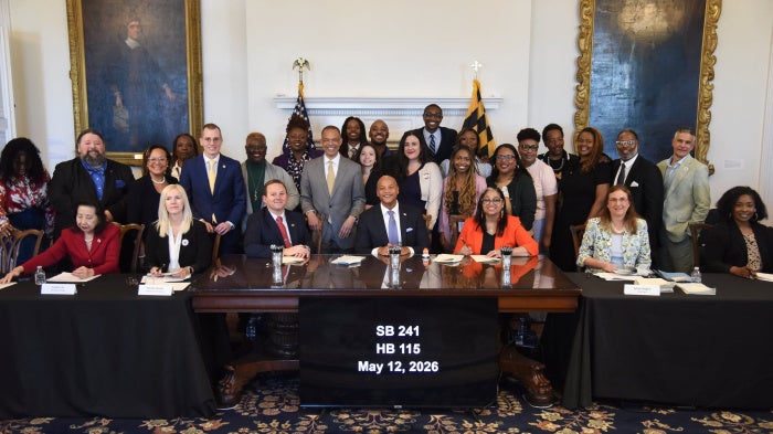Maryland Governor Wes Moore (center) along with advocates, organizers, and legislators after signing HB 115 and SB 241 at the Maryland State House in Annapolis, May 12, 2026. 
