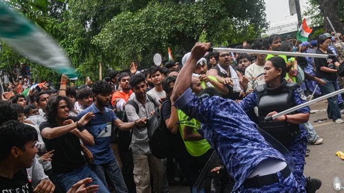 Police officers use batons to disperse protestors