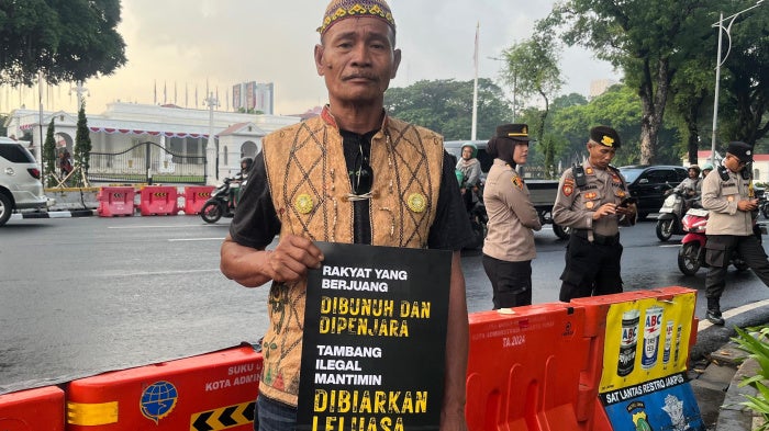 A man holds a placard at a demonstration