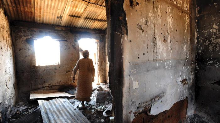 A woman walks through a house that was burned during the January 19, 2010 attack on Kuru Karama, Plateau State, which left more than 170 Muslims dead. 