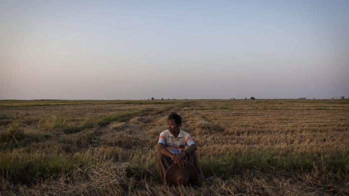 La Win, 61, a farmer from the Ayeyarwady Region, sits on a portion of the 35 acres of land he said was taken from him in 2004 by a company. 