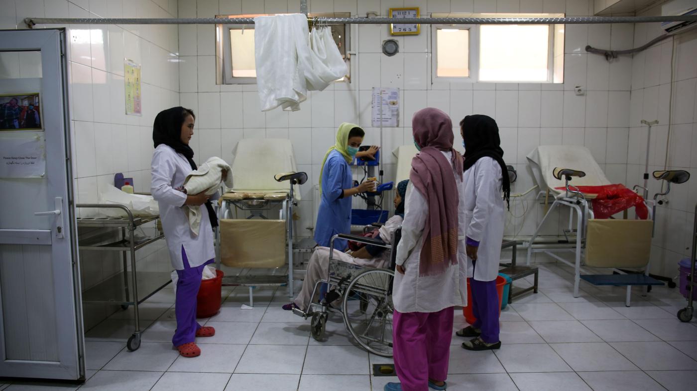 Midwives care for a mother who has just given birth in a hospital room