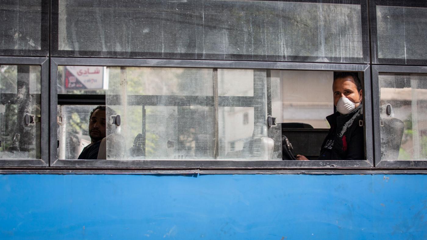 A man wearing a face mask rides in an almost empty bus in Cairo, Egypt, March 30, 2020.