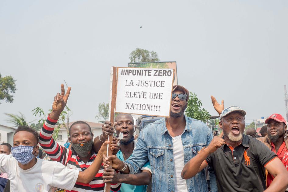 Protesters, including many motorbike-taxi drivers, demonstrate while holding placards for the second day around the Parliament in Kinshasa, June 24, 2020.